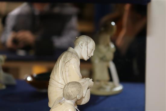 A Japanese ivory group of two figures with basket of oranges height 16cm